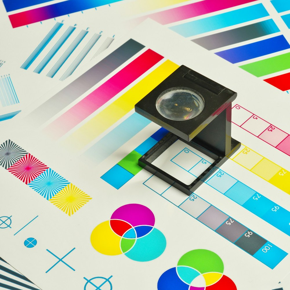Colour check with a loupe on a CMYK proof sheet